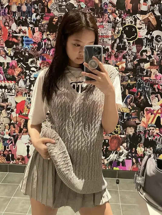 Jennie mengenakan vest knit sebagai luaran dengan inner tshirt putih. Ia pun memadukannya dengan mini skirt warna abu-abu. (@jennierubyjane)