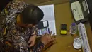 Salah satu anggota dewan terlihat asyik memainkan game di ponselnya saat menghadiri sidang paripurna pembukaan reses, Jakarta, Senin (23/3/2015). Sekitar 255 anggota dewan tak hadir dalam sidang pembukaan reses tersebut. (Liputan6.com/Faisal R Syam)
