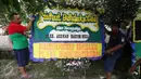 Pekerja menaruh Karangan bunga di rumah duka tokoh PBNU KH Hasyim Muzadi di Ponpes Al-Hikam, Depok, Jawa Barat, Kamis (16/3). Karangan bunga mulai berdatangan pascameninggalnya KH Hasyim Muzadi. (Liputan6.com/Immanuel Antonius)