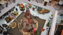 Salah satu mahasiswa berdiri di samping instalasi dekorasi berbentuk pohon Natal dengan motif budaya Papua di Perpustakaan Petra Christian University (PCU), Surabaya, Jawa Timur, Kamis 18 Desember 2025. Jelang perayaan Natal 2025, perpustakaan Petra Christian University (PCU) kembali menghadirkan instalasi dekorasi Pohon Natal tematik. (JUNI KRISWANTO/AFP)