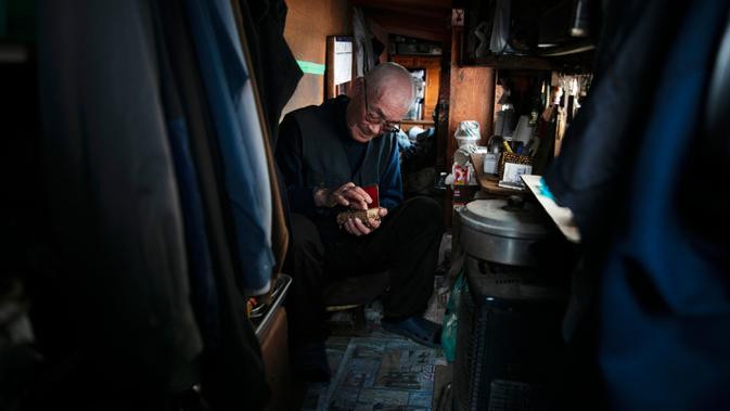 Seorang tunawisma Mikio Hirau (72) duduk dalam gubuknya di Kawasaki, Jepang, Selasa (14/1/2020). Menurut data pemerintah Jepang tahun 2017, hampir 16 persen warga Jepang berada di bawah garis kemiskinan dengan pendapatan tahunan di bawah 1,2 juta yen atau sekitar USD 11.000. (AP Photo/Jae C. Hong)