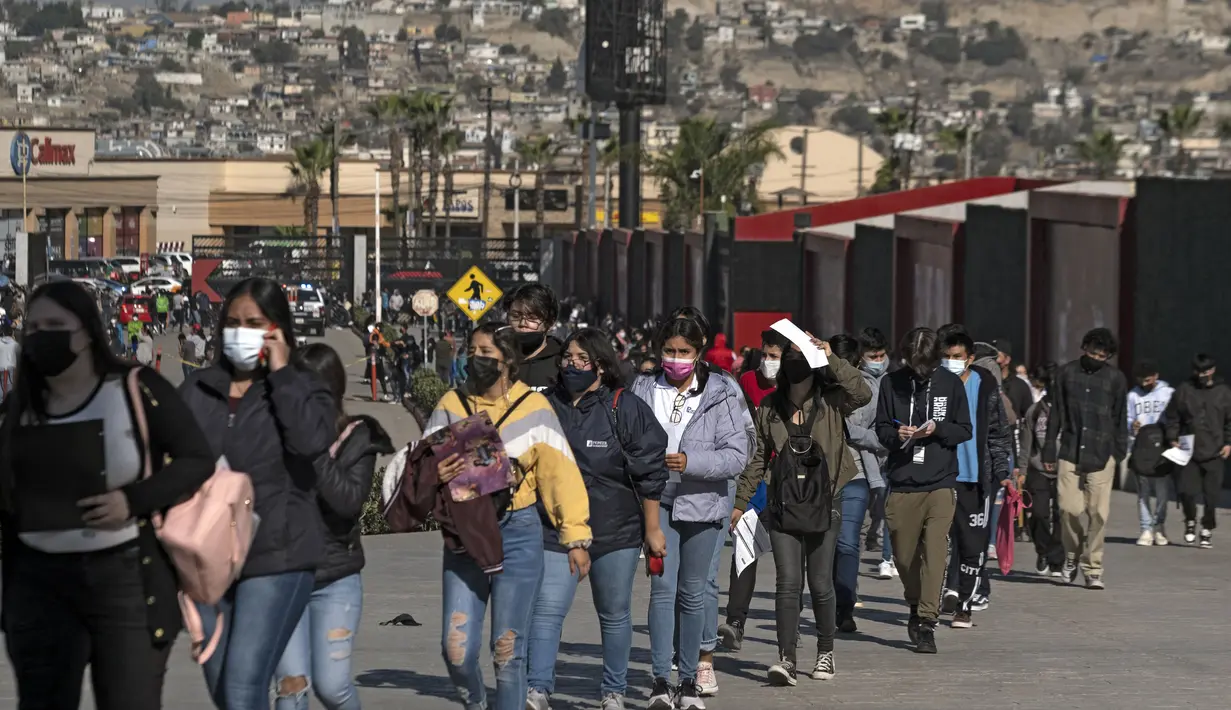 Anak-anak mengantre untuk divaksin COVID-19 dalam program vaksinasi untuk anak-anak berusia 15 hingga 17 tahun di Stadion Caliente, Tijuana, Baja California, Meksiko, 24 November 2021. Meksiko bersiap menghadapi gelombang keempat infeksi virus corona COVID-19. (Guillermo Arias/AFP)