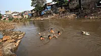 Sejumlah bocah berenang di Sungai Ciliwung, Jakarta, Selasa (13/10/2015). Berdasarkan data BPS DKI Jakarta, angka kemiskinan di Jakarta tahun 2015 mengalami penurunan 0,16 persen dibandingkan tahun lalu. (Liputan6.com/Immanuel Antonius)