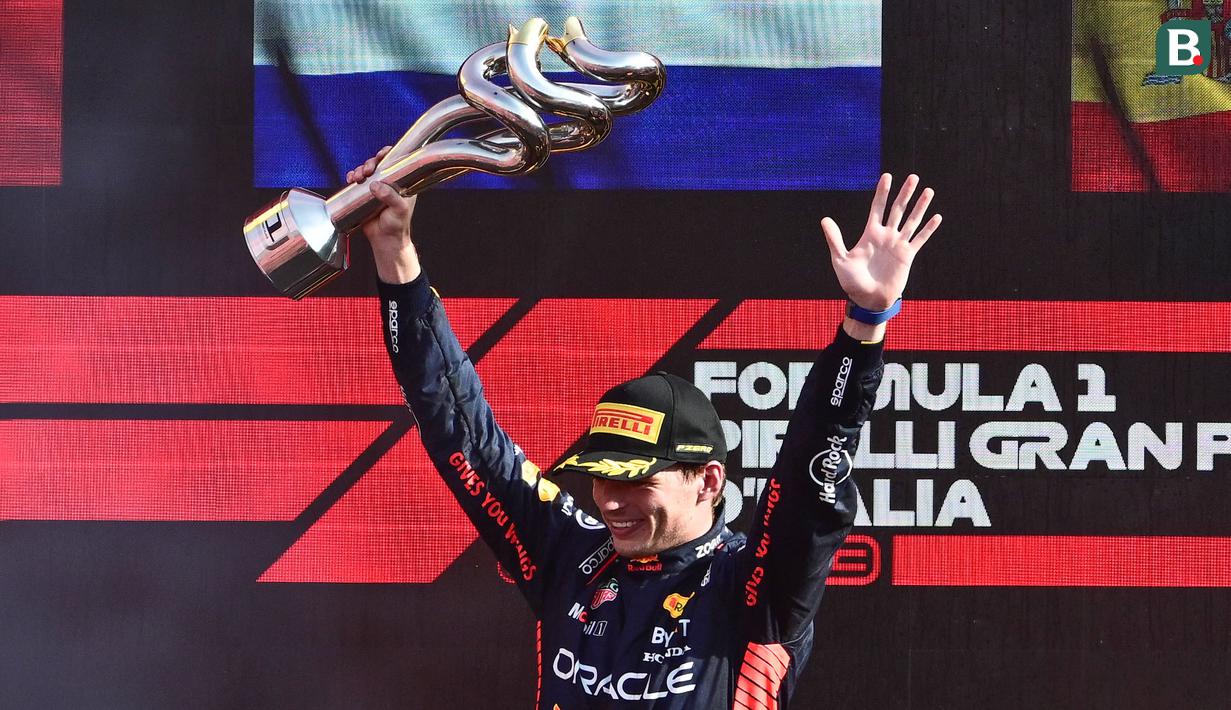 Pembalap Red Bull Racing, Max Verstappen merayakan kemenangan setelah finis tercepat di Formula 1 GP Italia 2023 yang berlangsung di Sirkuit Monza, Italia, Minggu (03/09/2023). Verstappen sukses mencatatkan 10 kemenangan secara beruntun di ajang F1 mengungguli rekor milik Sebastian Vettel (AFP/Marco Bertorello)