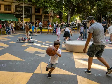 Seorang anak bermain dengan ayahnya di pusat kota Barcelona, Spanyol (25/6/2020). Spanyol telah memasuki tatanan "Normal Baru" pada 21 Juni, dengan mengizinkan kembali warga untuk bebas bepergian di seluruh wilayah negara tersebut. (Xinhua/Balai Kota Barcelona)