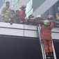 Petugas pemadam kebakaran mengevakuasi korban kebakaran di Gedung Cyber 1, Jakarta, Kamis (2/12/2021). Kebakaran Gedung Cyber 1 mengakibatkan satu orang meninggal dunia. (Liputan6.com/Herman Zakharia)