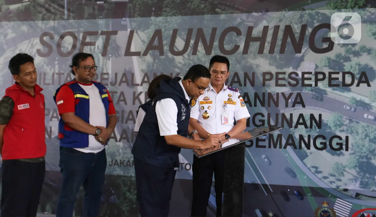 Gubernur DKI Jakarta Anies Baswedan membubuhkan tanda tangan di atas prasasti saat soft launching fasilitas pejalan kaki dan pesepeda pada proyek pembangunan dan penataan kawasan Semanggi di Taman Semanggi, Jakarta, Rabu (12/10/2022). (Liputan6.com/Herman Zakharia)
