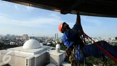 Salah satu relawan pecinta alam membersihkan atap menara Masjid Istiqlal, Jakarta, Jumat (17/2). Menyambut Milad Masjid Istiqlal ke-39, relawan pecinta alam bantu membersihkan Masjid Istiqlal. (Liputan6.com/Helmi Fithriansyah)