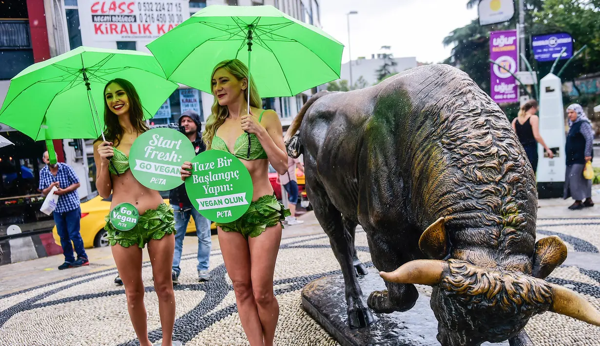 Dua aktivis wanita dari PETA yang menyebut diri mereka "Selada Ladies" memakai bikini daun selada mempromosikan gaya hidup vegan di Istanbul, Turki (17/8). Mereka mengajak masyarakat untuk beralih dengan gaya hidup vegetarian. (AFP Photo/Yasin Akgul)