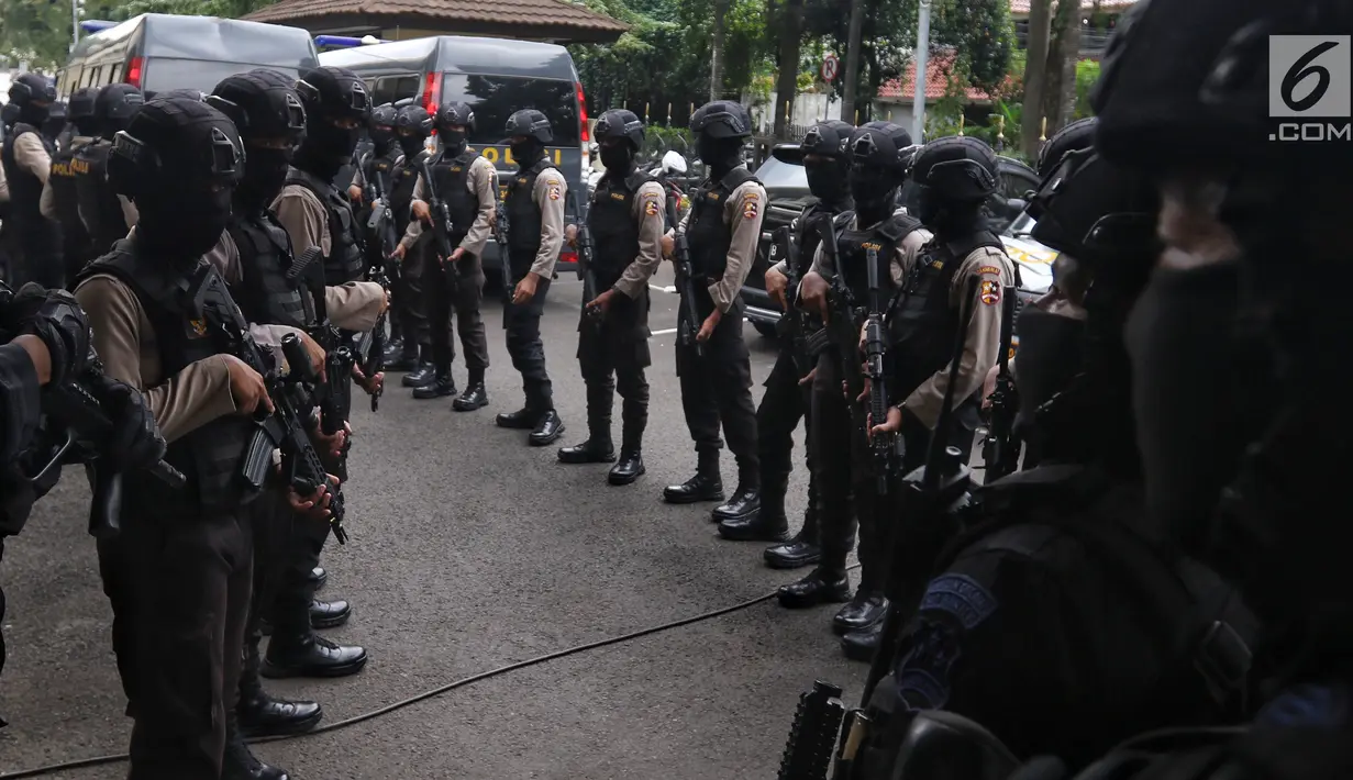 Polisi bersenjata lengkap mengawal sejumlah terduga teroris untuk dihadirkan dalam jumpa pers di Mabes Polri, Jakarta, Jumat (17/5/2019). Sepanjang bulan Mei 2019, tim Densus 88 Antiteror telah menangkap sebanyak 29 terduga teroris jaringan Jamaah Ansharut Daulah (JAD). (Liputan6.com/Johan Tallo)