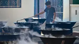 Hidangan ini berupa kari daging (sapi, kambing, atau kerbau) yang dimasak dengan nangka muda serta berbagai rempah pilihan dalam belanga besar. Tampak dalam foto, seorang pria memasak hidangan kari tradisional yang disebut 'kuah beulangong' untuk dibagikan saat berbuka puasa, sekaligus memperingati turunnya Al-Quran selama bulan suci Ramadan, di Banda Aceh pada Sabtu 7 Maret 2026. (CHAIDEER MAHYUDDIN/AFP)