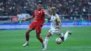 Bek tengah Persija, Rizky Ridho Ramadhani (kiri) berusaha menahan laju penyerang kiri Dewa United Banten FC, Noah Wail Sadaoui saat pertandingan lanjutan BRI Super League 2025/2026 di Jakarta International Stadium (JIS), Minggu (15/3/2026) malam WIB. Menjamu Dewa United Banten FC, Persija gagal memanfaatkan situasi dan mempertahankan keunggulan. (Bola.com/M Iqbal Ichsan)