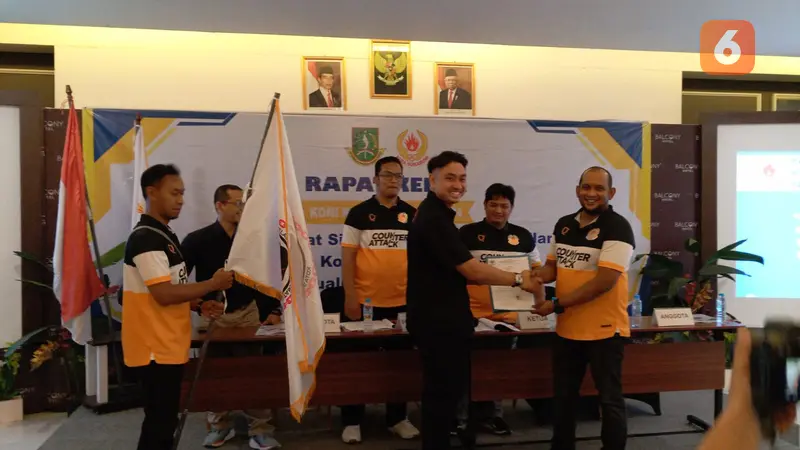 Ketua Umum IBCA-MMA Kota Sukabumi, Irsan P Munandar menyerahkan bendera IBCA-MMA kepada Ketua Koni Kota Sukabumi (Liputan6.com/Istimewa).