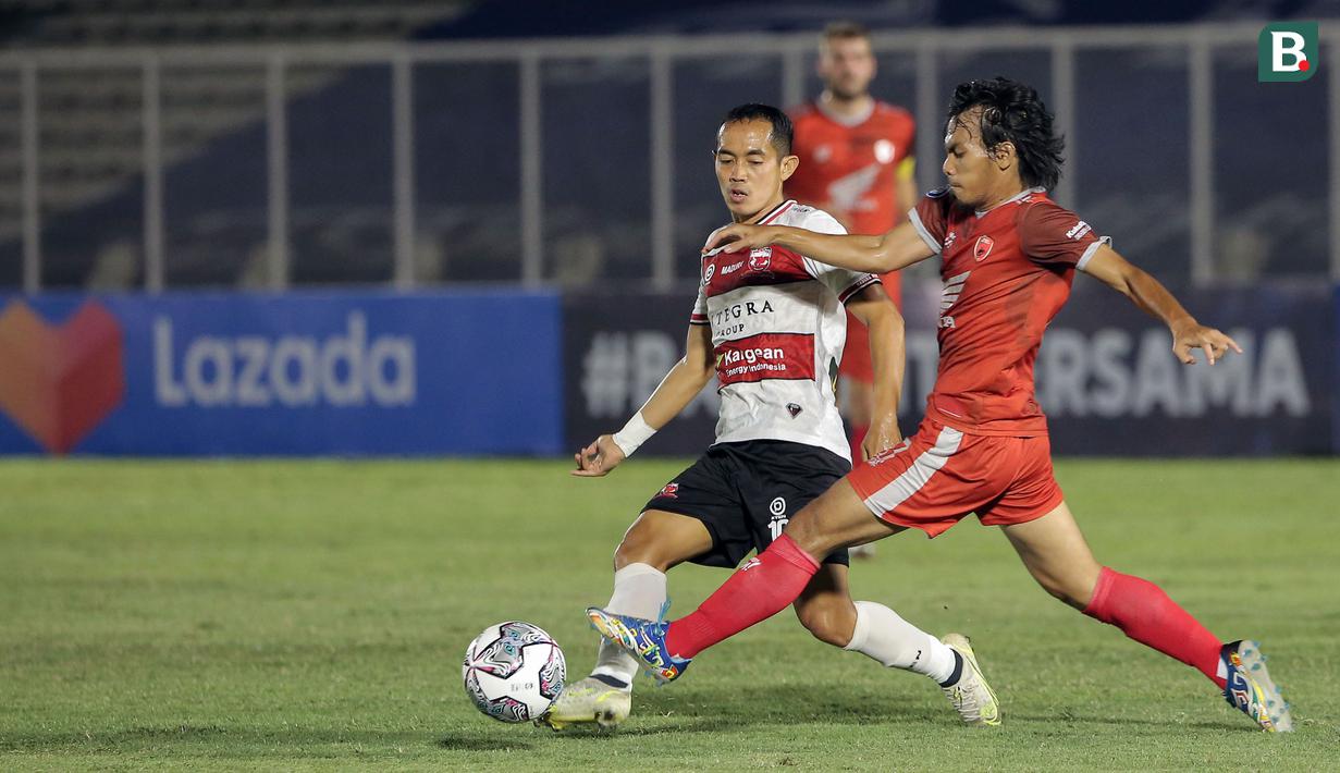 Pemain PSM Makassar, Rasyid Bakri (kanan) berebut bola dengan pemain Madura United, Slamet Nurcahyono (kiri) saat laga BRI Liga 1 2021/2022 antara Madura United melawan PSM Makassar di Stadion Madya, Jakarta, Minggu (12/9/2021). Pertandingan berakhir imbang 1-1. (Foto: Bola.com/Ikhwan Yanuar)
