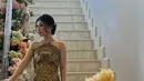 Saat prosesi sangjit, Putri tampil mengenakan dress berkerah tinggi warna gold dengan bordiran yang begitu detail. [@melindalamora]