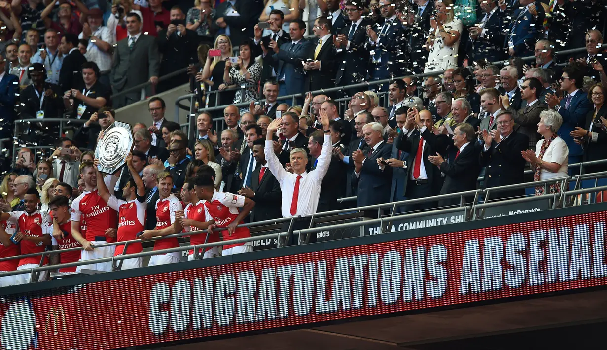 Pelatih Arsenal, Arsene Wenger merayakan kemenangan trofi Community Shield di Wembley Stadium, Minggu (2/8/2015). Arsenal menang atas Chelsea dengan skor 1-0. (Reuters/Dylan Martinez)