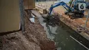 Alat berat mengeruk beton turap saluran air yang longsor di kawasan Jagakarsa, Jakarta, Kamis (17/9/2020). Selain karena hujan lebat, longsor diduga karena erosi tanah akibat pembuangan saluran air pencuci piring dan toilet dari warung makan di sekitar bantaran. (Liputan6.com/Immanuel Antonius)