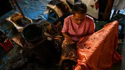 Seorang pekerja membuat desain batik di sebuah bengkel di Banda Aceh, Aceh, Rabu (13/10/2021). Untuk warna yang dominan dipakai dalam batik Aceh adalah warna cerah seperti merah muda, merah, kuning, hijau dan lainnya. (Chaideer MAHYUDDIN/AFP)