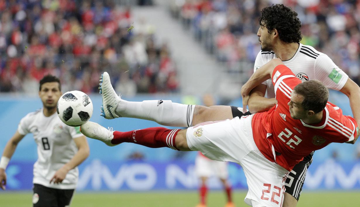 Bek Mesir, Ahmed Hegazy, berebut bola dengan striker Rusia, Artyom Dzyuba, pada laga Grup A Piala Dunia di Stadion Krestovsky, St Petersburg, Selasa (19/6/2018). Rusia menang 3-1 atas Mesir. (AP/Gregorio Borgia)