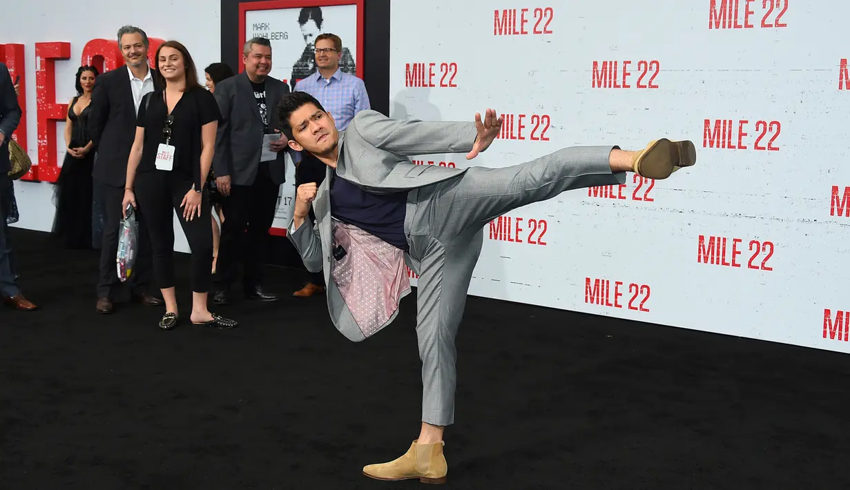 Bintang laga, Iko Uwais memamerkan gerakan pencak silat ketika menghadiri acara gala premier film Mile 22 di Los Angeles, Kamis (9/8). Iko Uwais tampil dalam balutan setelan jas abu-abu yang dipadukan dengan kaus warna gelap. (Jordan Strauss/Invision/AP)