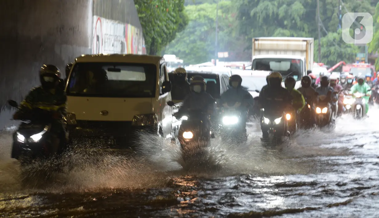Sejumlah kendaraan melewati banjir yang merendam terowongan di Cawang, Jakarta, Jumat (19/2/2021). Hujan yang turun sejak semalam membuat sejumlah jalanan di Ibu Kota tergenang banjir dengan ketinggian sekitar 30-50 cm. (merdeka.com/Imam Buhori)