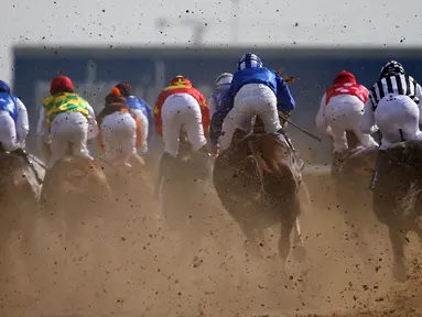 Para joki berlomba dalam lomba pacuan kuda Dubai Kahalya Classic yang menjadi bagian dalam Dubai World Cup di lintasan pacuan kuda Meydan, UEA, (26/3/2016). (AFP/Marwan Naamani)