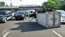 Sebuah mobil boks terbalik di KM 02 Tol Cawang arah Cililitan, Jakarta, Senin (30/5). Mobil boks bernomor polisi B 9385 HH itu terbalik tepat di tengah jalan di lajur samping Gerbang Tol Cilitan arah ke Taman Mini. (Liputan6.com/Yoppy Renato)