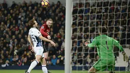 Pemain Manchester United, Wayne Rooney menyundul bola melewati pemain West Bromwich Albion pada laga Premier League di The Hawthorns stadium, West Bromwich, (17/12/2016). MU menang 2-0. (AFP/Oli Scarff) 
