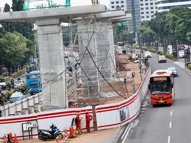 Bus transjakarta melintas di samping proyek LRT di kawasan Kuningan, Jakarta Selatan, Rabu (21/2). Presiden Jokowi meminta semua proyek konstruksi layang (elevated) dihentikan sementara. (Liputan6.com/Immanuel Antonius)