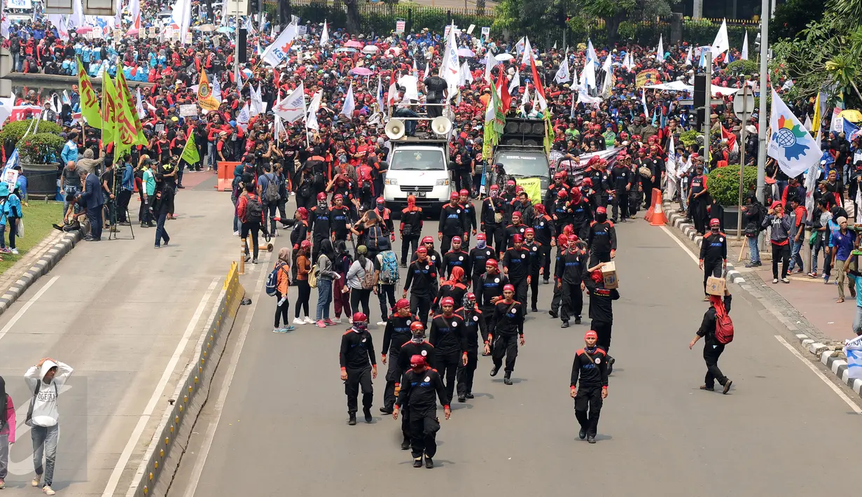 Massa buruh berjalan memasuki ruas Jalan Medan Merdeka Barat saat perayaan hari Buruh Internasional di Kawasan Patung Patung Arjuna Wiwaha, Jakarta, Senin (5/1). Ribuan massa buruh ikut dalam perayaan MayDay 2017. (Liputan6.com/Helmi Fithriansyah)