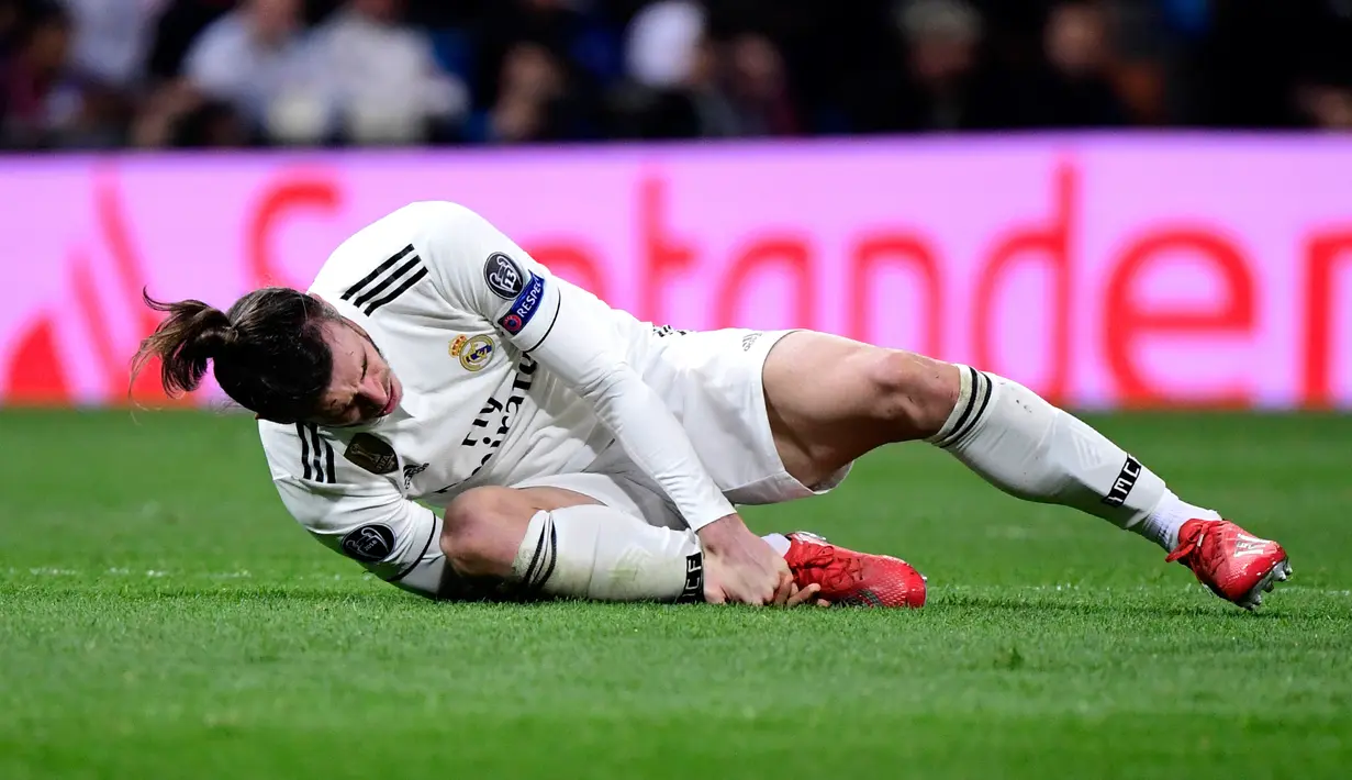 Pemain depan Real Madrid Gareth Bale memberi isyarat kesakitan saat menghadapi Ajax Amsterdam pada leg kedua babak 16 besar Liga Champions di Stadion Santiago Bernabeu, Madrid, Spanyol, Selasa (5/3). (JAVIER SORIANO/AFP)