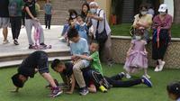 Anak-anak bermain selama Hari Anak Internasional di sebuah mal di Beijing, China, Selasa (1/6/2021). Partai Komunis China yang berkuasa mengatakan akan melonggarkan batas kelahiran untuk memungkinkan semua pasangan memiliki tiga anak, bukan dua. (AP Photo/Ng Han Guan)