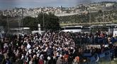 Warga Palestina mengantre bus setelah menyeberang dari Kota Bethlehem di Tepi Barat ke Yerusalem untuk mengikuti sholat Jumat di Kompleks Masjid Al Aqsa selama bulan suci Ramadhan, Jumat (31/3/2023). (AP Photo/Mahmoud Illean)