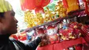 Pedagang merapikan boneka bertema Imlek di kawasan Glodok, Jakarta, Kamis (31/1). Pernak-pernik Imlek bershio babi tanah sudah mulai ramai dijual. (Liputan6.com/Herman Zakharia)
