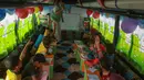 Anak-anak Suriah mengikuti pelajaran di dalam bus yang dikonversi menjadi ruang kelas di desa Hazano di barat laut Suriah (15/9/2019). Pelajaran di kelas bus ini yaitu bahasa Arab, matematika, sains, dan kadang-kadang bahasa Inggris , serta menyanyi dan menggambar. (AFP Photo/Aaref Watad)