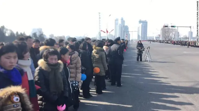 Warga Korea Utara menanti parade militer Korea Utara di Pyongyang melintas. Parade itu digelar sehari jelang pembukaan Olimpiade Musim Dingin PyeongChang 2018 (KCNA)