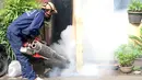 Petugas melakukan penyemprotan asap di salah satu rumah di kawasan Menteng Atas dan Menteng Tenggulun, Jakarta, Senin (8/5). Penyemprotan asap dilakukan untuk mencegah perkembangbiakan nyamuk demam berdarah. (Liputan6.com/Helmi Fithriansyah)