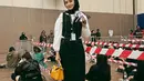 Untuk kesan chic dan edgy, bisa tiru gaya Dhatu Rembulan yang memadukan kemeja putihnya dengan vest dan maxi skirt hitam. Ia pun menambahkan sling bag kuning sebagai statement. [@dhaturembulan].