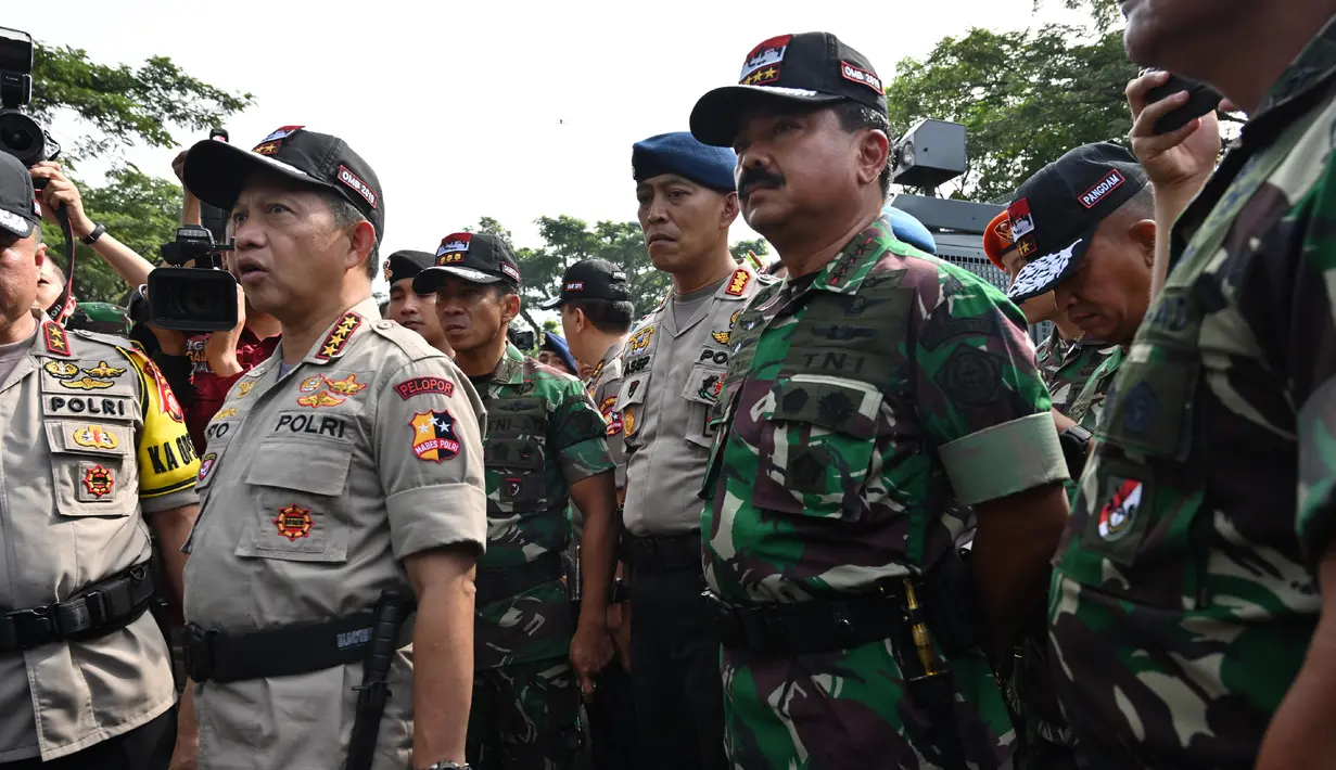 Panglima TNI Marsekal Hadi Tjahjanto (kanan) dan Kapolri Jenderal Tito Karnavian menghadiri apel pengamanan Pemilu 2019 di Bogor, Jawa Barat, Rabu (10/4). Panglima TNI dan Kapolri mengecek langsung kesiapan dan perlengkapan personel untuk mengamankan Pemilu 2019. (ADEK BERRY/AFP)