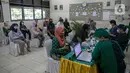Sejumlah tenaga pendidik sebelum mengikuti vaksin COVID-19 di SMP 216, Jakarta Pusat, Selasa (6/4/2021). Menurut Menteri Kesehatan Budi Gunadi Sadikin, pemerintah akan memprioritaskan kelompok lansia dan juga tenaga pengajar dalam vaksinasi kali ini. (Liputan6.com/Faizal Fanani)