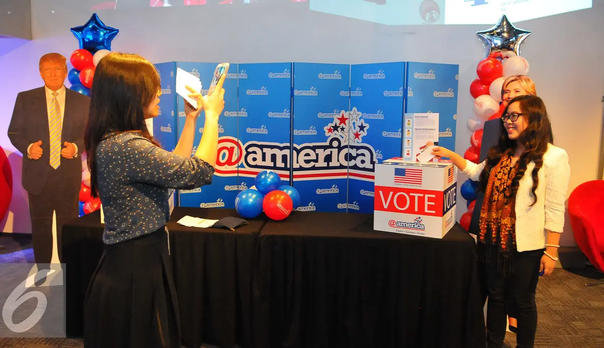 Pengunjung berfoto saat mengikuti simulasi vote pemilihan Presiden Amerika Serikat di @america di Jakarta, Rabu (9/11). Dalam pilpres kali ini dua kandidat bersaing merebut sekitar 543 electoral votes di 50 negara bagian. (Liputan6.com/Angga Yuniar)