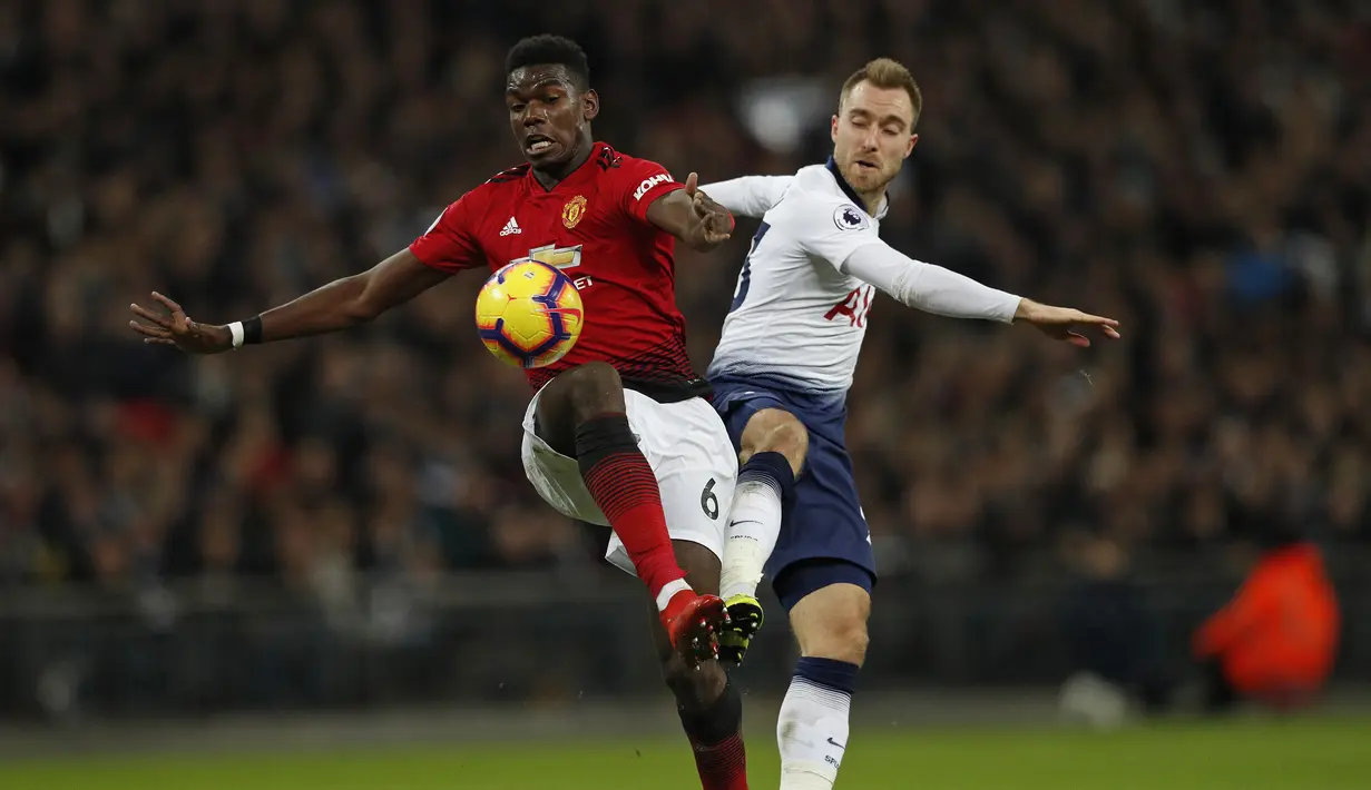 Paul Pogba berduel dengan Christian Eriksen pada laga lanjutan Premier League yang berlangsung di stadion Wembley, Inggris, Minggu (13/1). Man United menang atas Tottenham Hotspur 1-0. (AFP/Adrian Dennis)