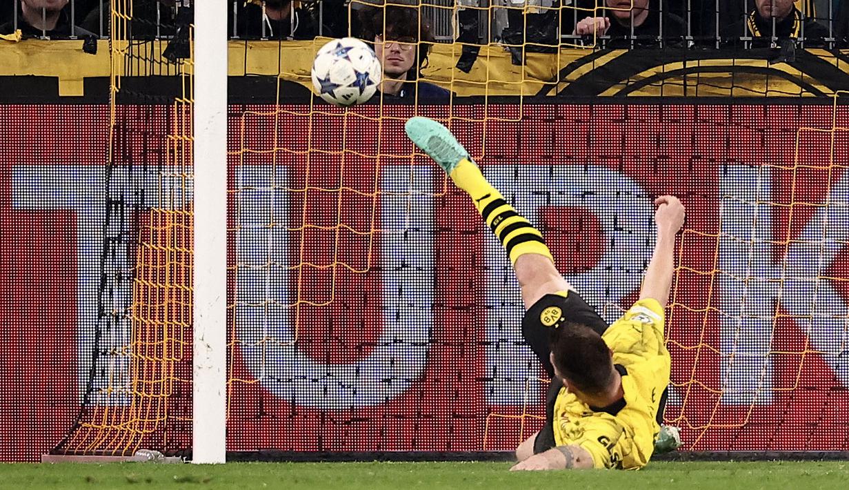 Pemain Borussia Dortmund, Niklas Sule mementahkan bola tendangan dari pemain PSG, Kylian Mbappe pada laga lanjutan Grup F Liga Champions 2023/2024 di Signal Iduna Park, Dortmund, Jerman, Kamis (14/12/2023) dini hari WIB. (AFP/Franck Fife)