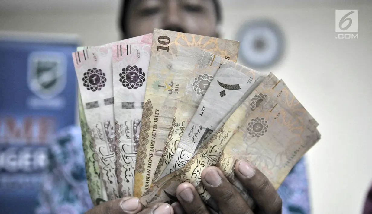 Calon jemaah haji menunjukkan  mata uang riyal di Asrama Haji Pondok Gede, Jakarta, Senin (22/7/2019). Embarkasi Haji Pondok Gede menyediakan empat titik pelayanan penukaran pecahan mata uang rupiah ke riyal. (merdeka.com/Iqbal Nugroho)