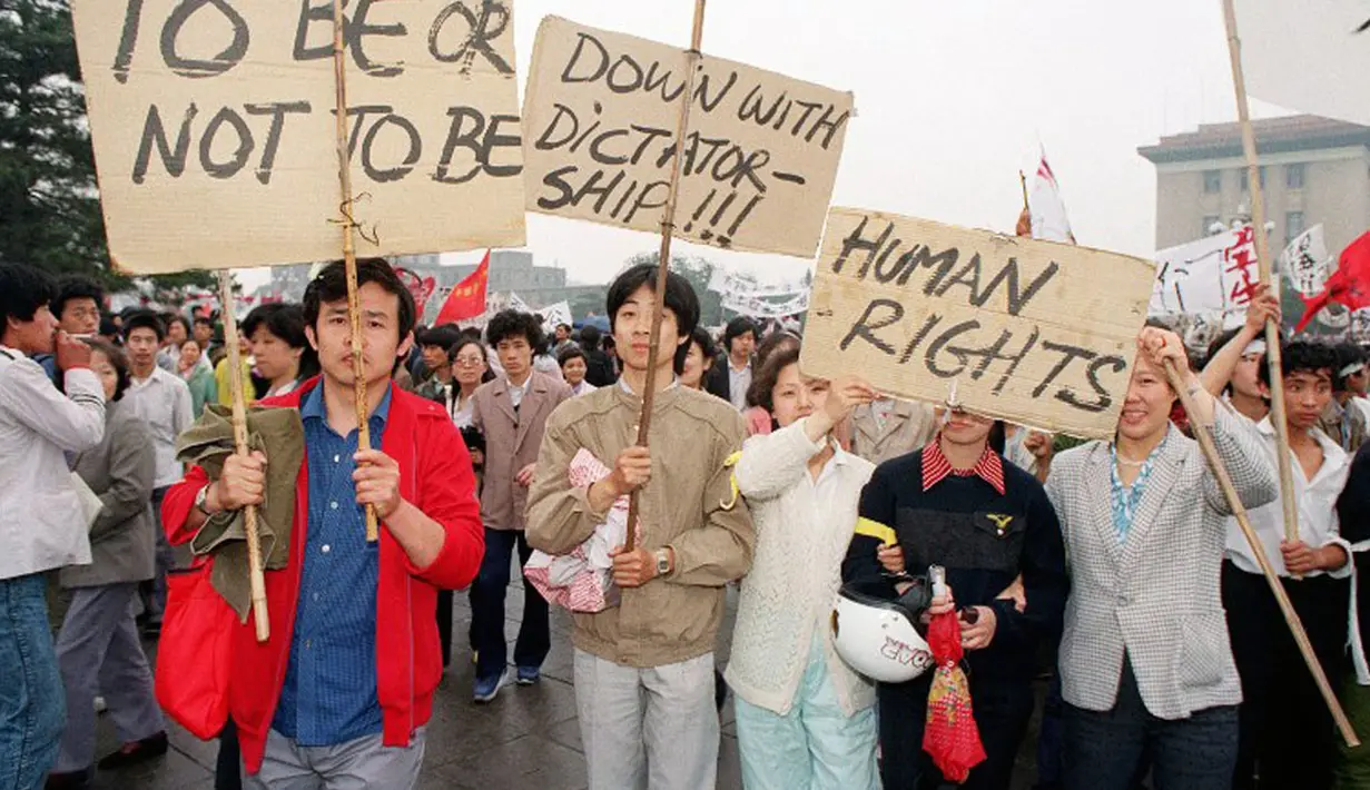 18 Mei 1989, sejumlah warga membawa tulisan berbahasa Inggris saat berunjuk rasa mendukung aksi mogok makan para mahasiswa di Lapangan Tiananmen, Tiongkok. (AFP PHOTO/CATHERINE Henriette)