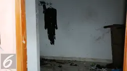 Sebuah baju terlihat robek dan tergantung di dalam rumah kos-kosan terduga anggota jaringan teroris, Bekasi (11/12). Menurut pihak kepolisian, bomnya rencananya akan diledakkan besok harinya, pada saat pergantian jaga Paspampres. (Liputan6.com/JohanTallo)