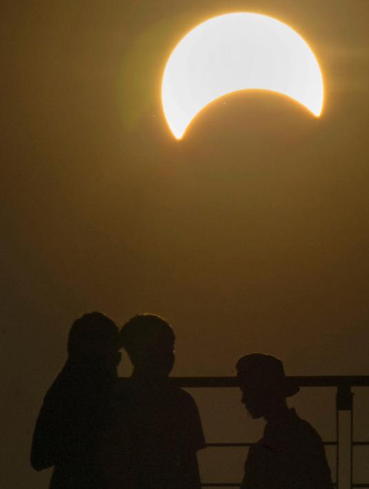 Masyarakat Aceh menyaksikan fenomena gerhana matahari yang terjadi di langit Banda Aceh, Rabu (9/3/2015). (Chaideer Mahyuddin/AFP)