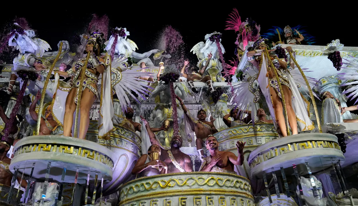 Penampil dari sekolah samba Vila Isabel berparade di atas kendaraan hias saat perayaan karnaval di Sambadrome, Rio de Janeiro, Brasil, Selasa (21/2/2023). Para anggota sekolah samba di Brasil tampil pada parade karnaval di Sambadrome, Rio de Janeiro, Brasil. Karnaval terbesar di dunia tersebut merupakan kompetisi parade tahunan di stadion raksasa yang diubah menjadi jalan-jalan raya dikenal sebagai "Sambadrome". (AP Photo/Silvia Izquierdo)