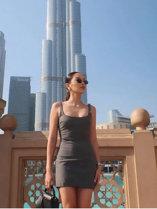 Saat berada di Dubai, mantan Al Ghazali ini mengenakan mini dress  strap warna abu-abu. Dengan kacamata dan aksesori anting-anting emasnya. [@alyssadaguise]