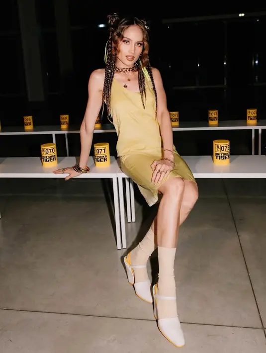 Melengkapi tampilannya dengan alas kaki heels tertutup warna putih. Dipadukan kaos kaki warna beige panjang. [@claurakiehl]